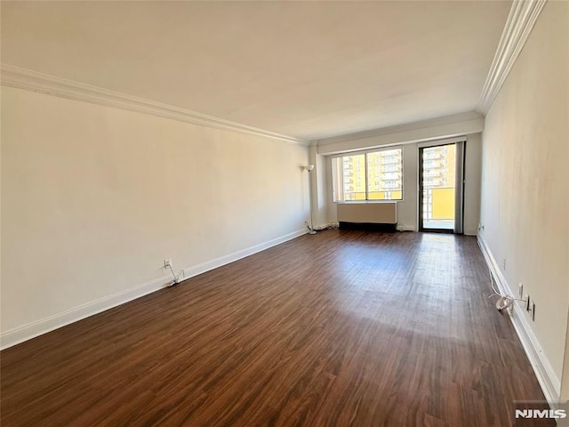 empty room featuring dark wood-type flooring and crown molding