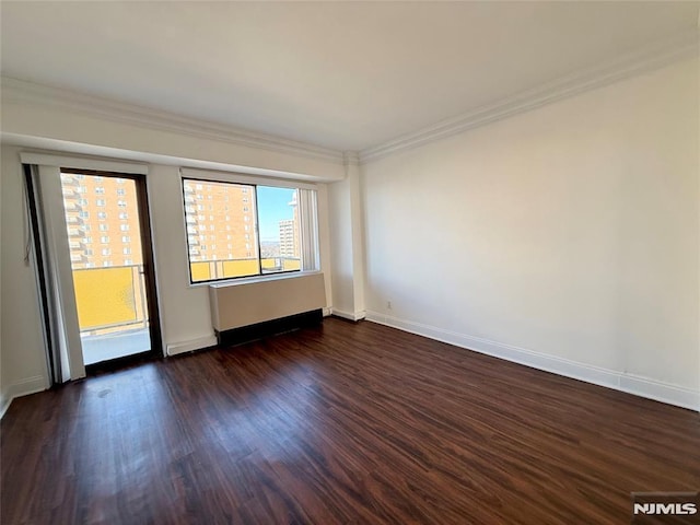 spare room featuring dark hardwood / wood-style flooring and ornamental molding