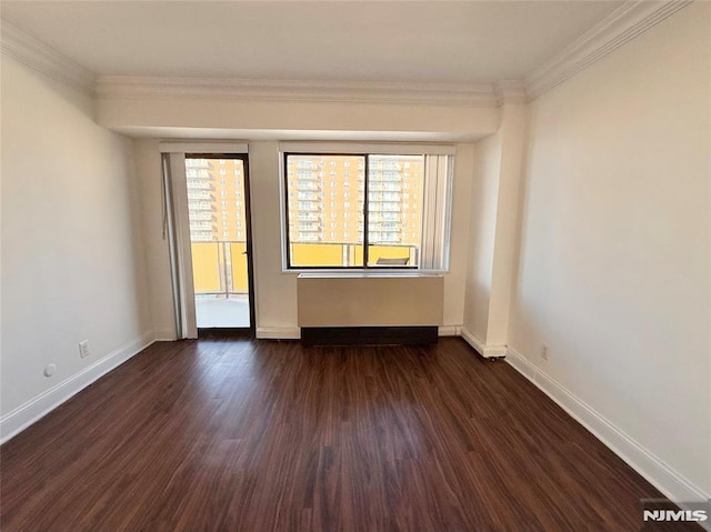 spare room featuring dark hardwood / wood-style floors and crown molding