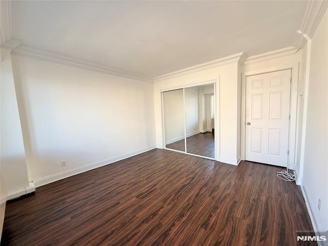 unfurnished bedroom with a closet, dark hardwood / wood-style flooring, and ornamental molding