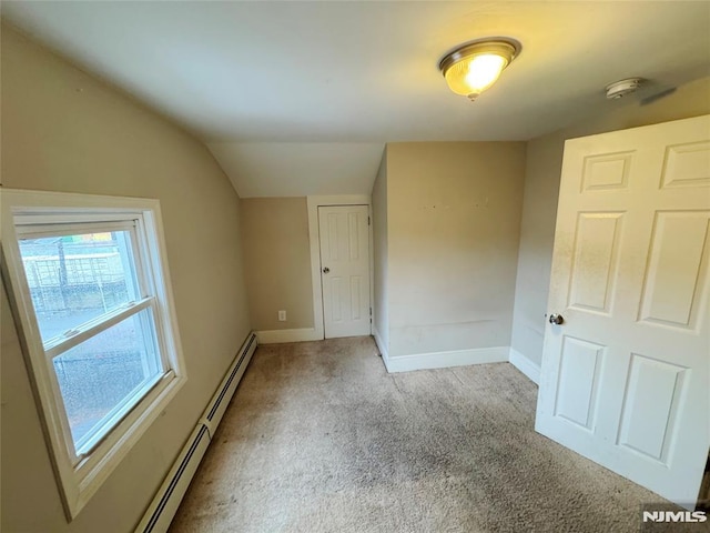 unfurnished room with light carpet, lofted ceiling, and a baseboard heating unit