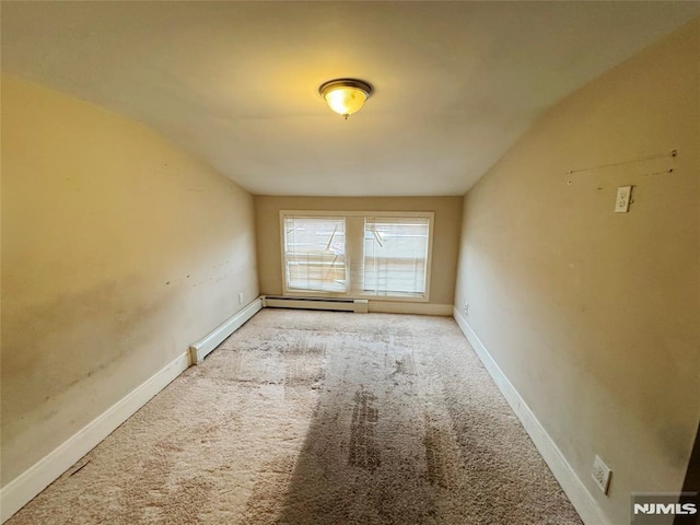 carpeted empty room with lofted ceiling and a baseboard radiator