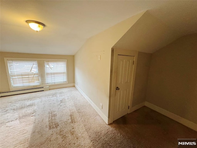 additional living space featuring carpet floors, a baseboard radiator, and vaulted ceiling