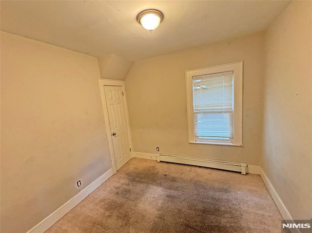 carpeted empty room with lofted ceiling and a baseboard radiator