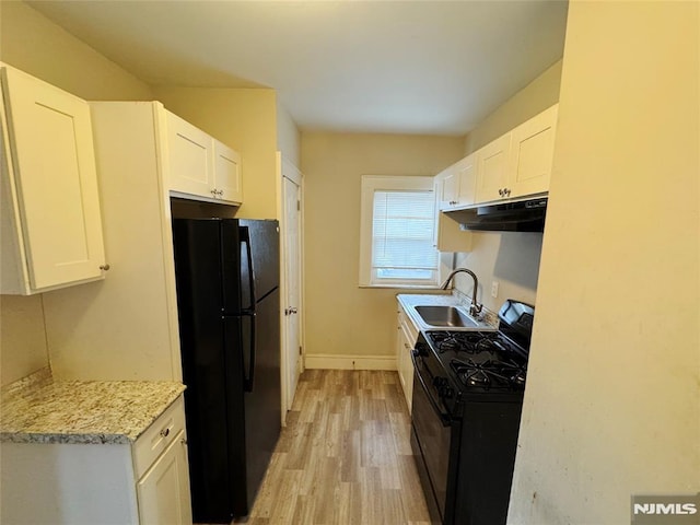 kitchen with white cabinetry, light hardwood / wood-style floors, light stone countertops, black appliances, and sink