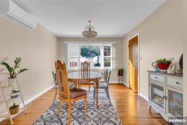 dining room with a wall mounted AC and light hardwood / wood-style floors