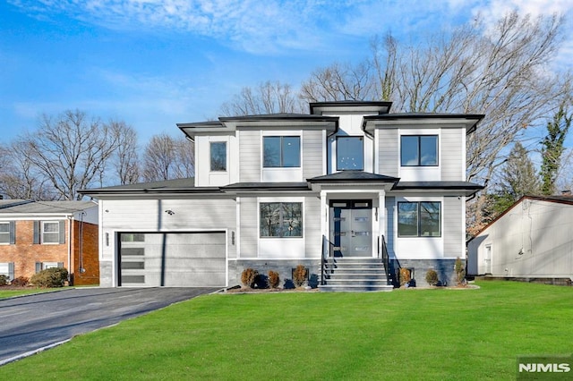 prairie-style home featuring a garage and a front lawn