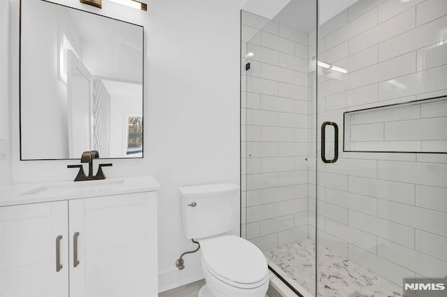 bathroom with toilet, vanity, and a shower with door