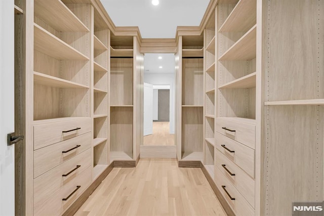 spacious closet featuring light hardwood / wood-style floors