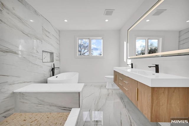 bathroom with toilet, plenty of natural light, and vanity