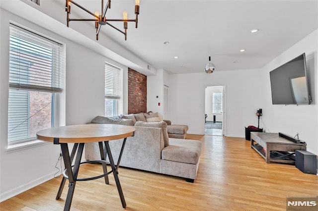 living room with light wood-type flooring and an inviting chandelier