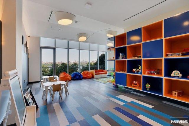 recreation room with a wall of windows and carpet