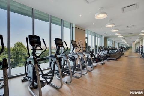 workout area with a wall of windows and light wood-type flooring