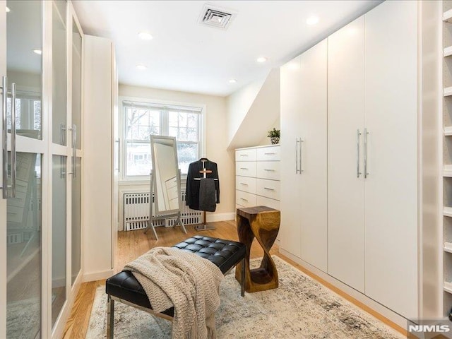 living area with light hardwood / wood-style floors and radiator