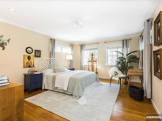 bedroom with ornamental molding and hardwood / wood-style floors