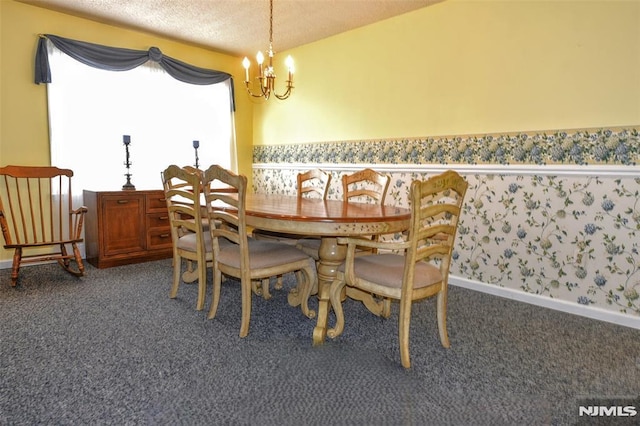 carpeted dining room featuring a textured ceiling and a chandelier