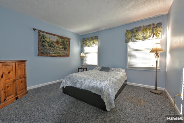 carpeted bedroom featuring multiple windows and a textured ceiling