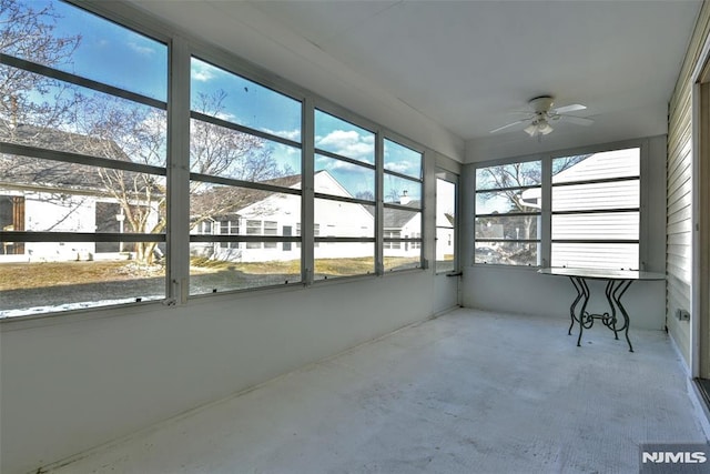 unfurnished sunroom featuring ceiling fan