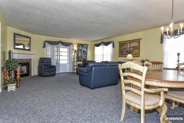 carpeted living room featuring a brick fireplace, a textured ceiling, and a notable chandelier