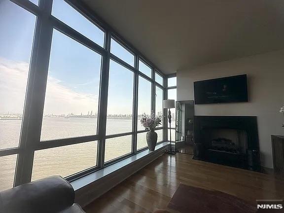 sunroom featuring a wealth of natural light and a water view