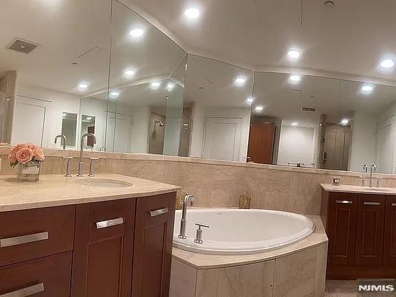 bathroom with shower with separate bathtub and vanity