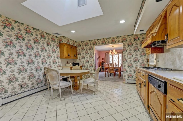 kitchen featuring stainless steel gas stovetop, light tile patterned flooring, paneled dishwasher, baseboard heating, and a chandelier