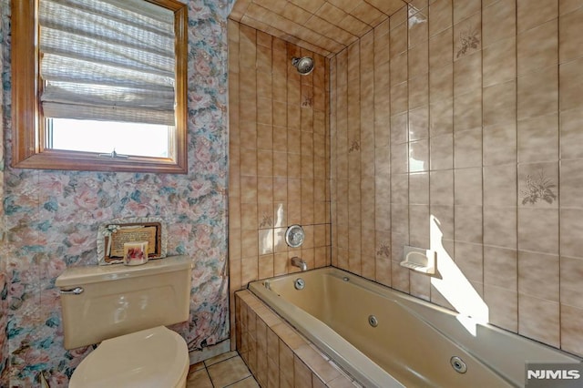 bathroom featuring tile patterned floors, toilet, and tiled shower / bath combo