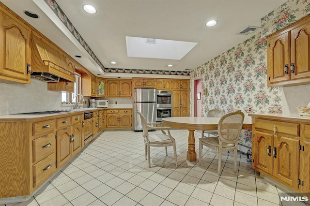 kitchen with light tile patterned floors, a skylight, appliances with stainless steel finishes, and sink