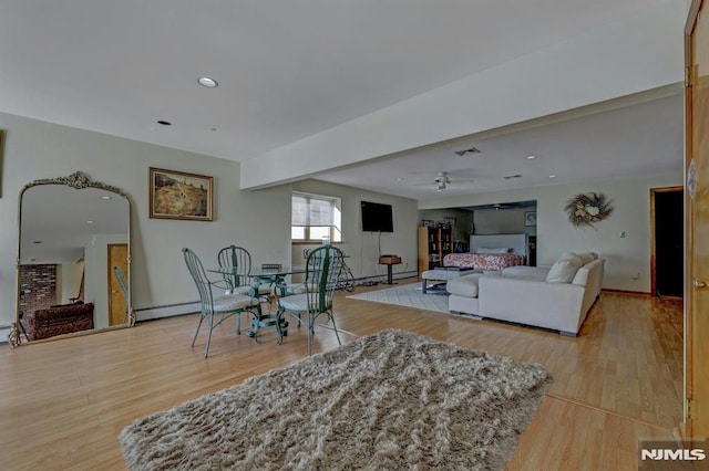 living room featuring ceiling fan and light hardwood / wood-style floors