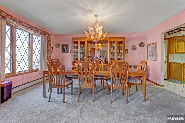 carpeted dining space featuring a baseboard heating unit and a notable chandelier