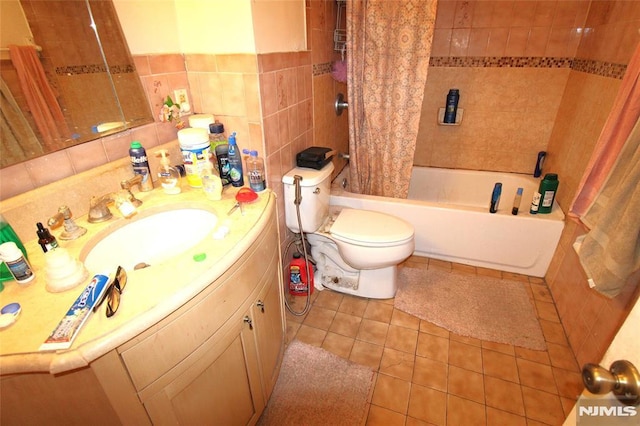 full bathroom featuring shower / tub combo with curtain, tile walls, vanity, toilet, and tile patterned floors