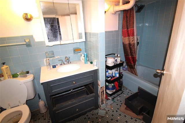 full bathroom featuring tile walls, vanity, shower / tub combo, toilet, and tile patterned floors