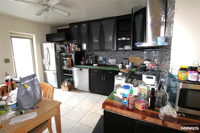 kitchen featuring stainless steel appliances, light tile patterned flooring, ceiling fan, and decorative backsplash