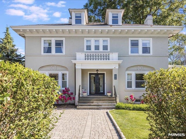 view of front of property with french doors and a balcony