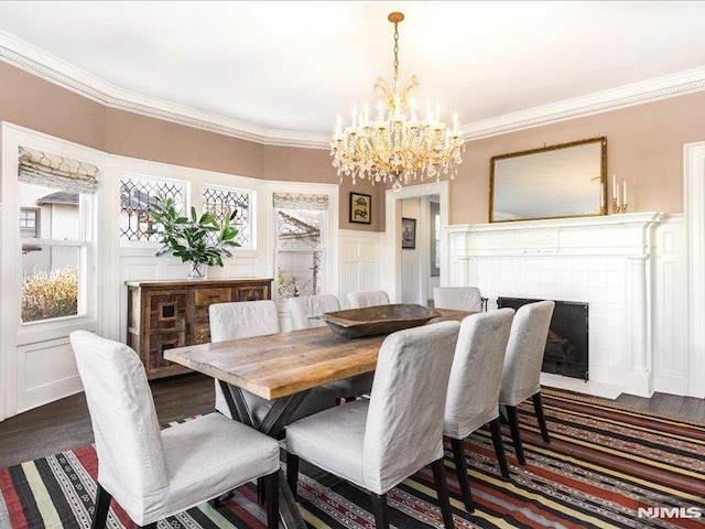 dining room featuring dark wood-type flooring, crown molding, and a chandelier