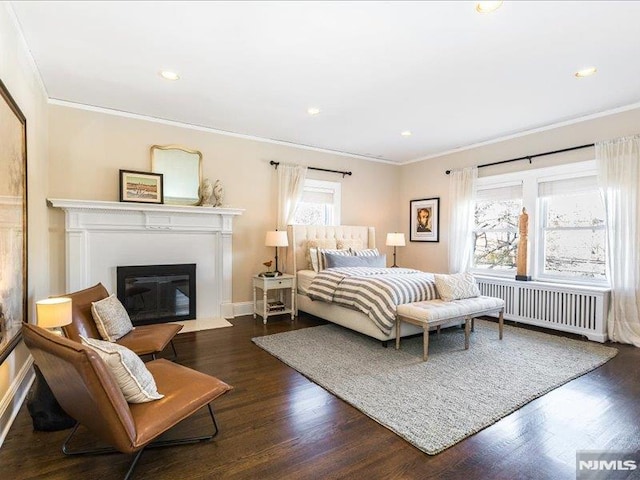 bedroom featuring crown molding, dark hardwood / wood-style floors, and radiator heating unit