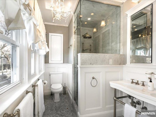 bathroom featuring toilet, a shower with door, a notable chandelier, tile patterned floors, and ornamental molding