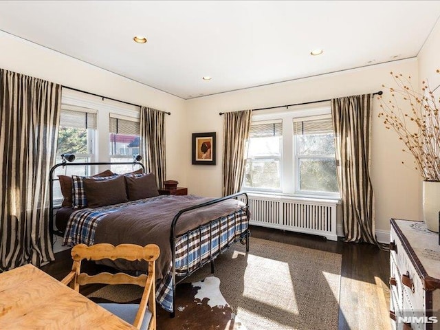 bedroom featuring radiator and dark hardwood / wood-style floors