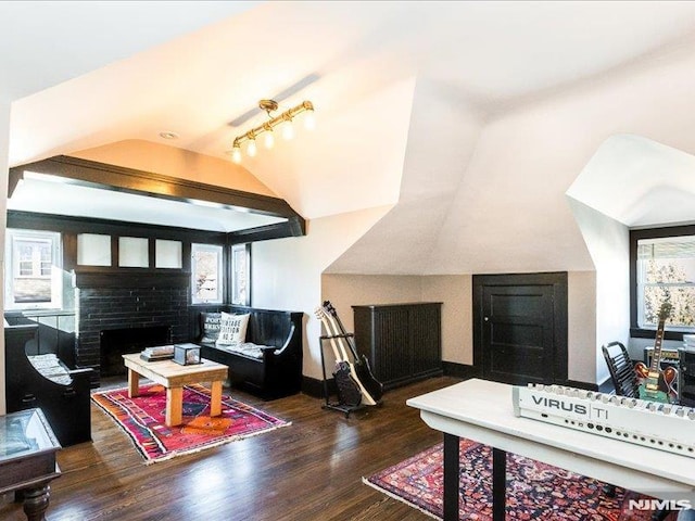 living room with a brick fireplace, dark wood-type flooring, and vaulted ceiling