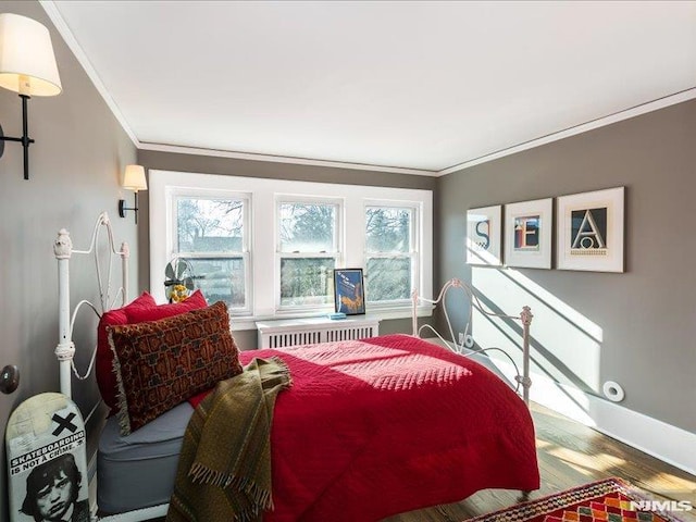 bedroom with radiator, crown molding, and hardwood / wood-style floors