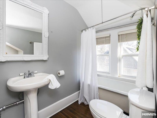 bathroom featuring toilet, vaulted ceiling, shower / tub combo with curtain, and hardwood / wood-style floors