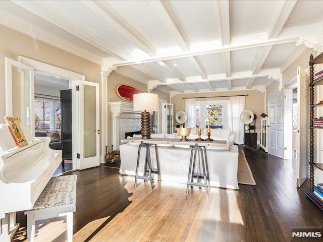 kitchen featuring beamed ceiling, a breakfast bar area, french doors, dark hardwood / wood-style flooring, and ornate columns