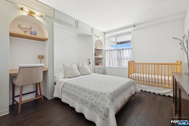 bedroom with dark hardwood / wood-style floors and built in desk