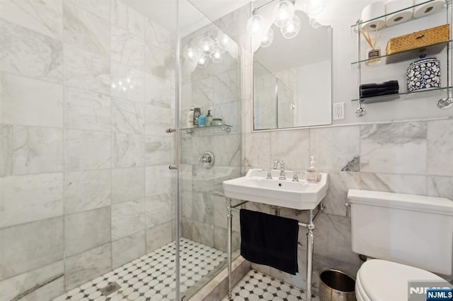 bathroom with tile walls, sink, toilet, and walk in shower