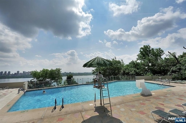 view of pool featuring a water view and a patio area