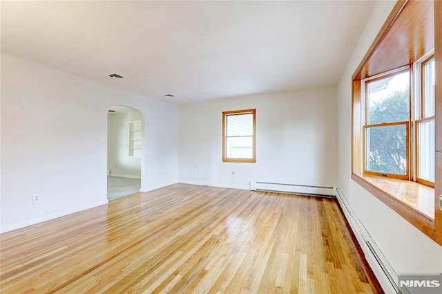 unfurnished room with a wealth of natural light, light hardwood / wood-style floors, and a baseboard radiator