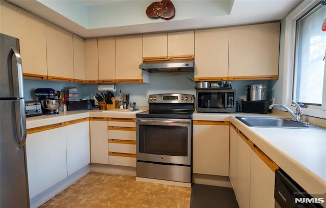 kitchen featuring stainless steel appliances, cream cabinetry, and sink