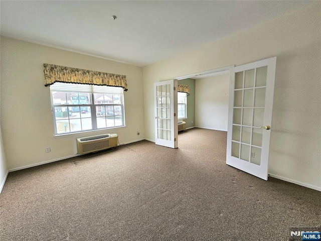 carpeted empty room featuring french doors and a wall unit AC