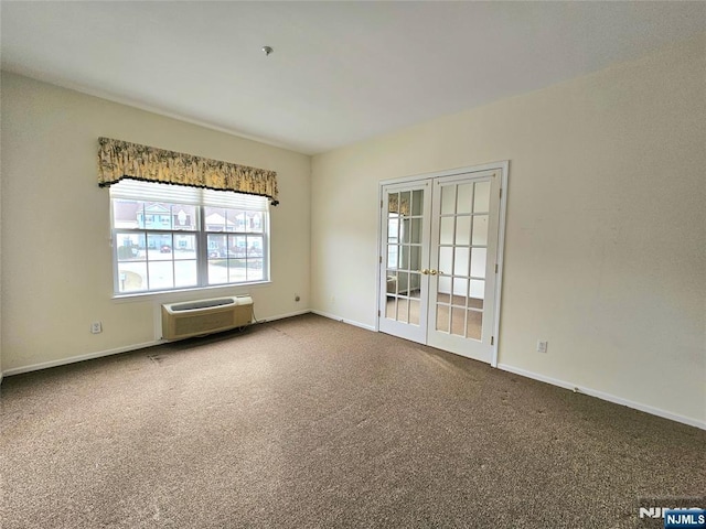 empty room with carpet flooring, a wall mounted AC, and french doors