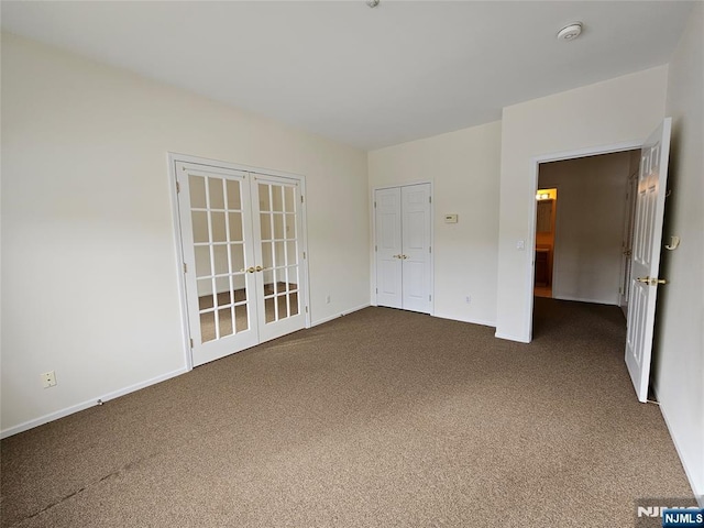 carpeted empty room featuring french doors